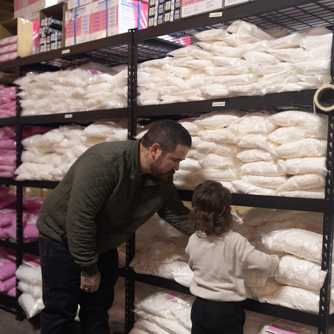 Photo of a man showing his child a bag of hard wax beads for hair removal.