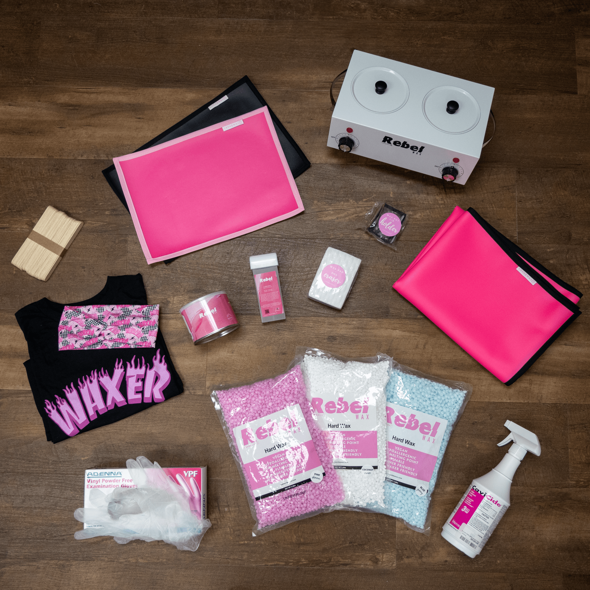 photo of a collection of waxing supplies for hair removal, wax warmer pot, Rebel Wax t-shirt and disinfectant spray.